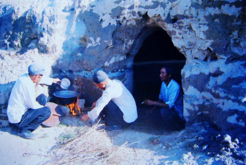 1983年，“六老漢”一代治沙人在“地窩子”生活做飯。新華社發（八步沙林場供圖）